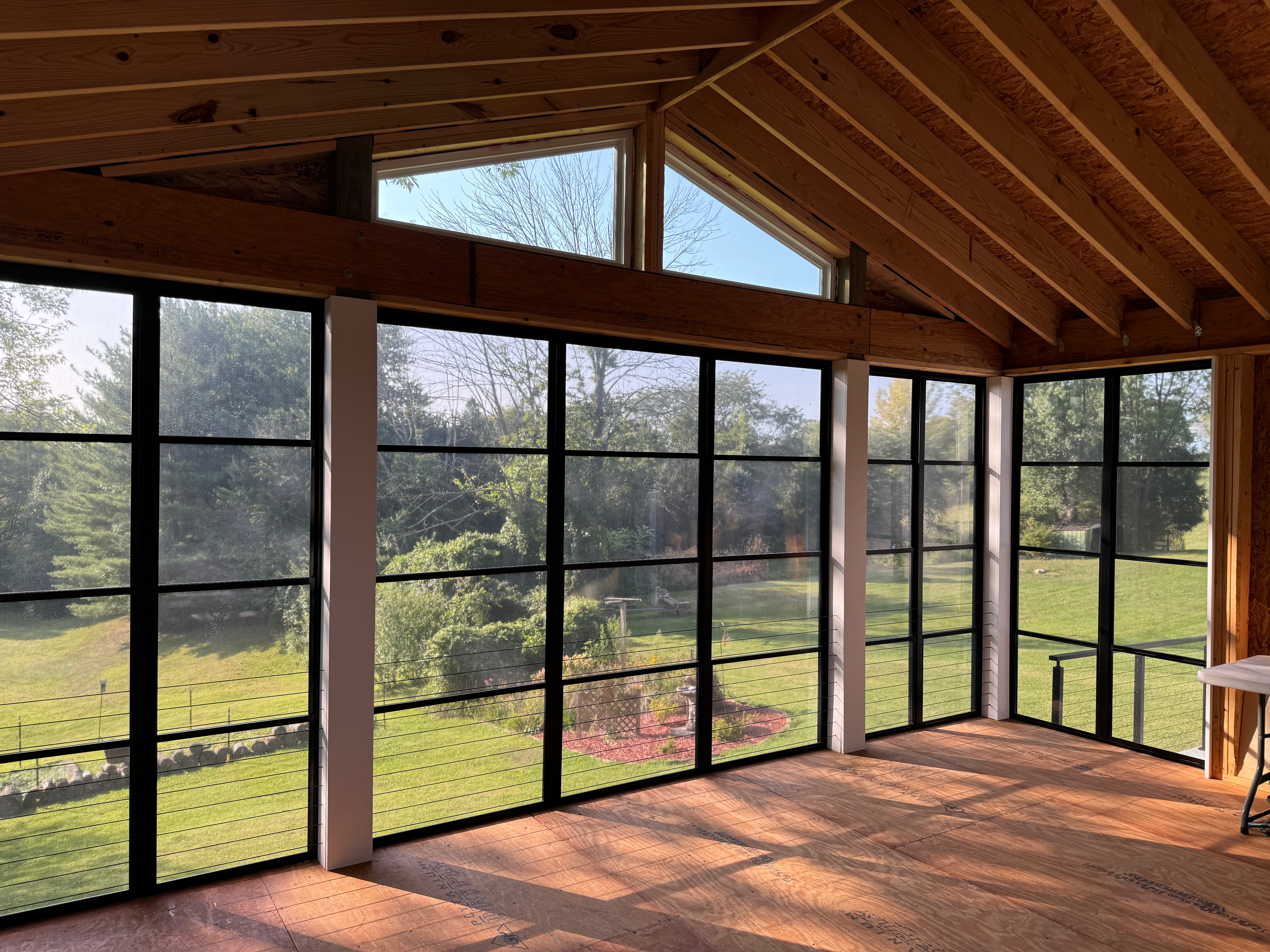 Bare sunroom overlooking a backyard on a sunny day.
